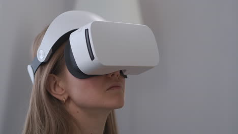 portrait-of-woman-with-head-mounted-display-female-user-is-looking-around-in-apartment-closeup-view-of-face-virtual-reality-technology